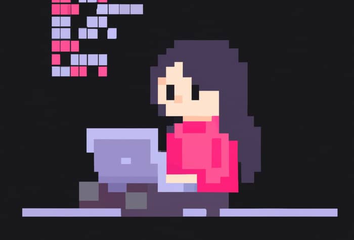A pixel art illustration of a person with long dark hair wearing a pink sweater, sitting at a desk and working on a laptop.  There are pixelated blocks, possibly representing code, in the upper left corner.