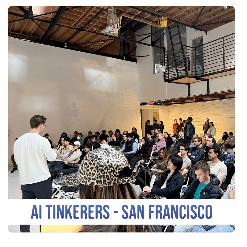 (Photo) A photo of a presentation or talk being given to a seated audience in a large, industrial-style room. Text: AI TINKERERS - SAN FRANCISCO people | indoor | presentation, audience, industrial venue | candid Note: The image is a real-life captured image of an event, showing a speaker and an audience in a specific venue. This makes it a photograph.