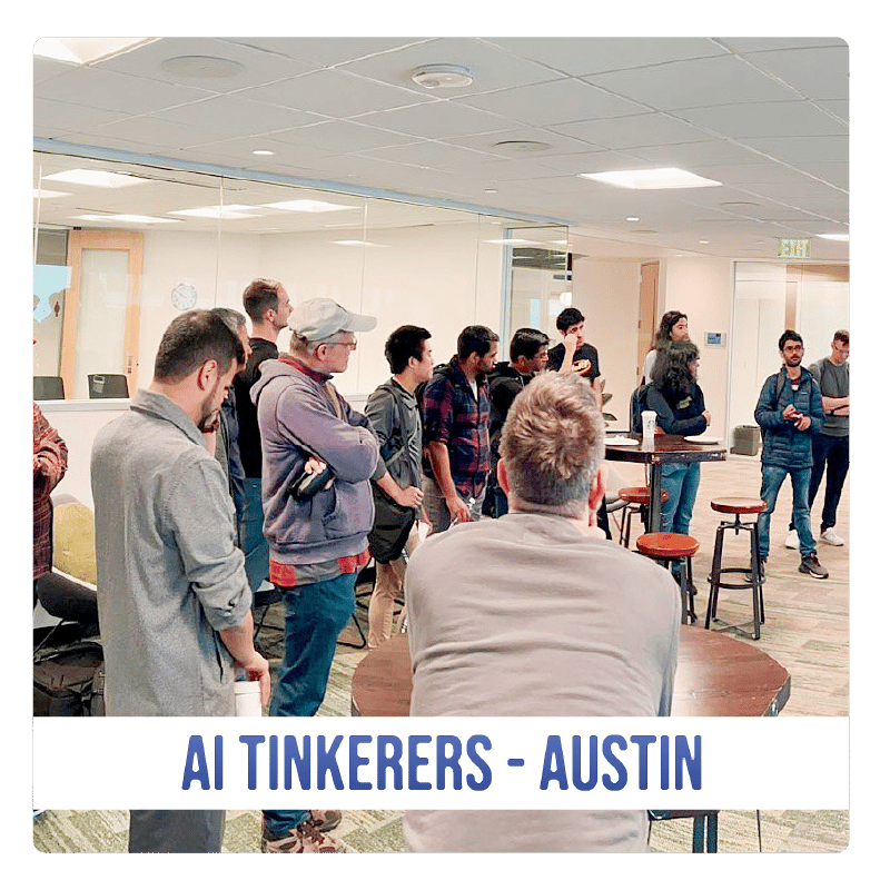 (Photo) A photo of a group of people gathered in a room, likely for a meeting or presentation. Text: AI TINKERERS - AUSTIN people | indoor | group of people, presentation/meeting setting | candid Note: The image is a real-life captured image of people in a room, making it a photograph. The text banner at the bottom suggests it documents an event.