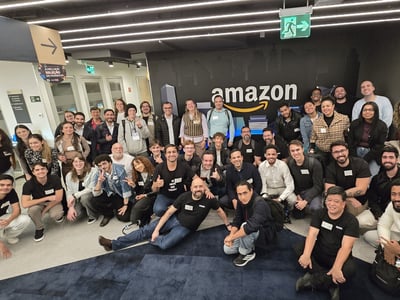 A large group of people posing for a group photo inside an Amazon office lobby.