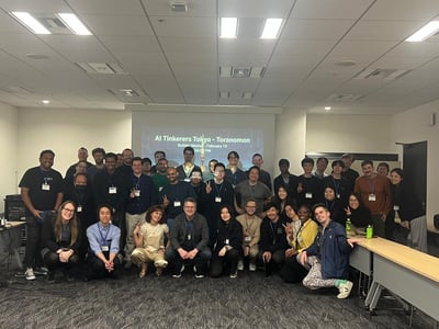 A group photo of approximately 40 people attending an 'AI Tinkerers Tokyo' meetup in an indoor office or event space.