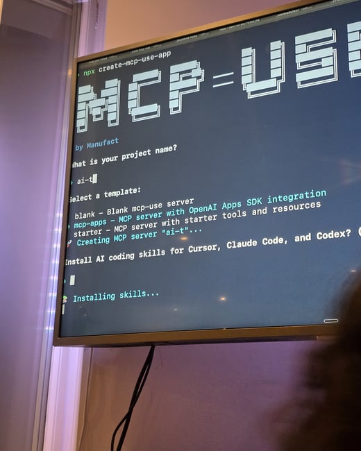 A photograph of a computer monitor displaying a terminal window running a command-line tool for project setup.