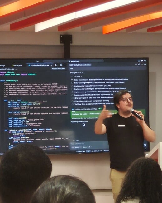 A man is giving a presentation in front of a large screen displaying Python code and a checklist in Portuguese, while holding a microphone.