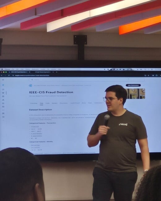 A man is giving a presentation in front of a large screen displaying the IEEE-CIS Fraud Detection competition page on Kaggle.