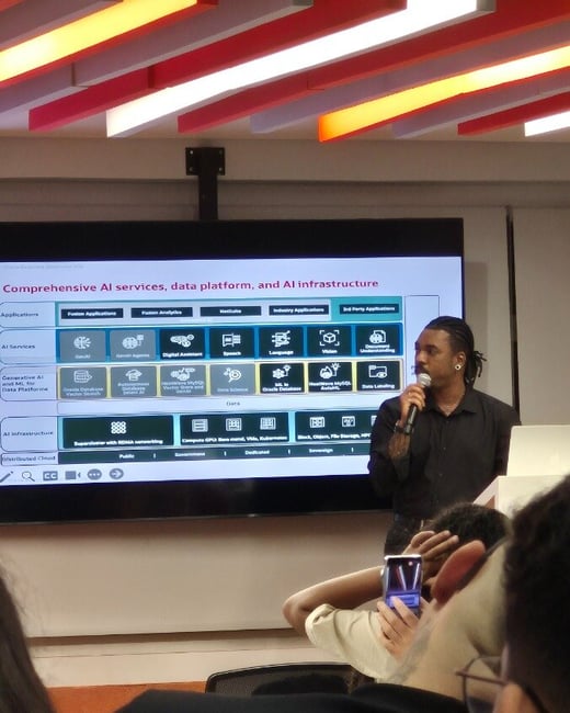 A man is giving a presentation in front of a large screen displaying a technical diagram titled 'Comprehensive AI services, data platform, and AI infrastructure'.