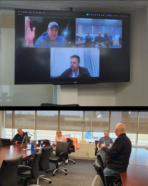 A composite image showing a hybrid meeting, with a video conference screen at the top and a physical conference room with participants at the bottom.