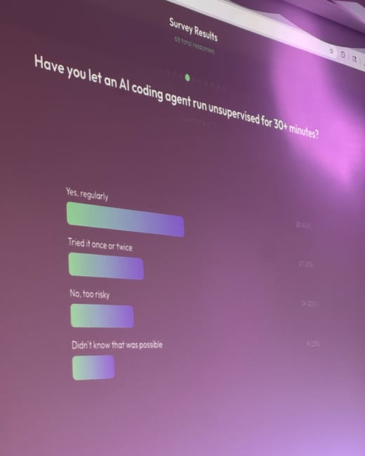 A candid photograph of a computer screen displaying survey results regarding the use of unsupervised AI coding agents, set against a dark purple background with strong magenta reflections.