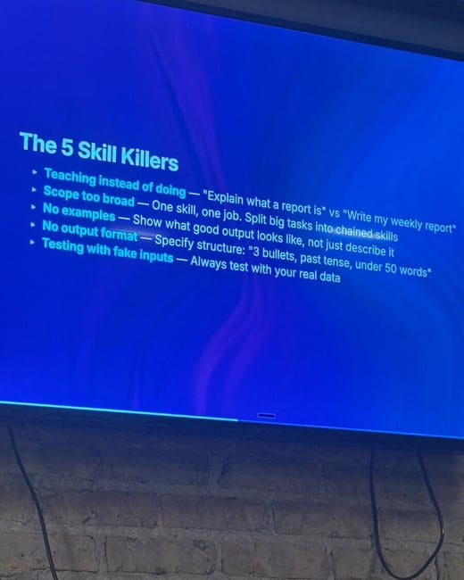 A photograph of a television screen displaying a presentation slide titled 'The 5 Skill Killers' against a blue background, mounted on a brick wall.