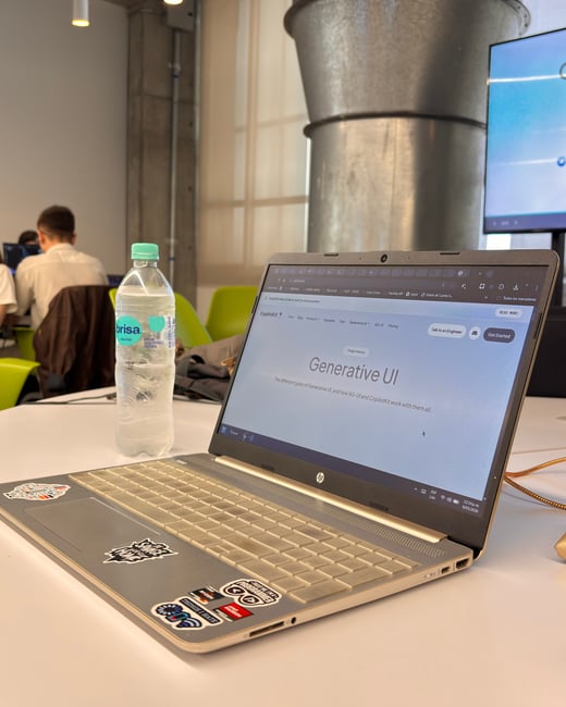 A laptop sits on a white desk in an office environment, displaying a webpage about 'Generative UI' alongside a bottle of water.