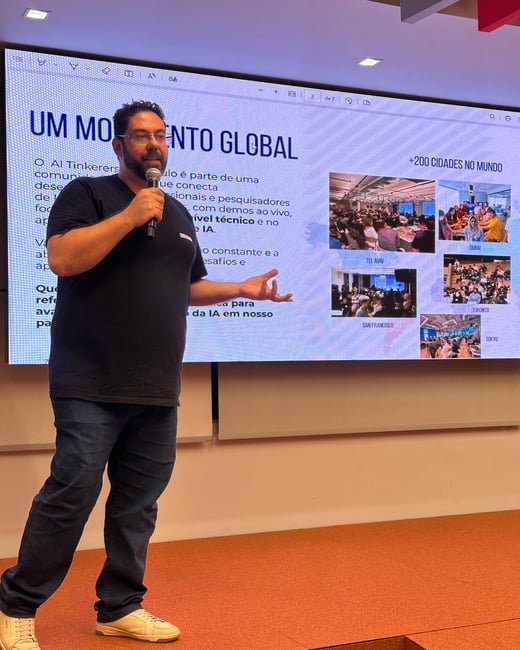 A man is giving a presentation on stage in front of a large screen showing information about 'AI Tinkerers' and its global presence.