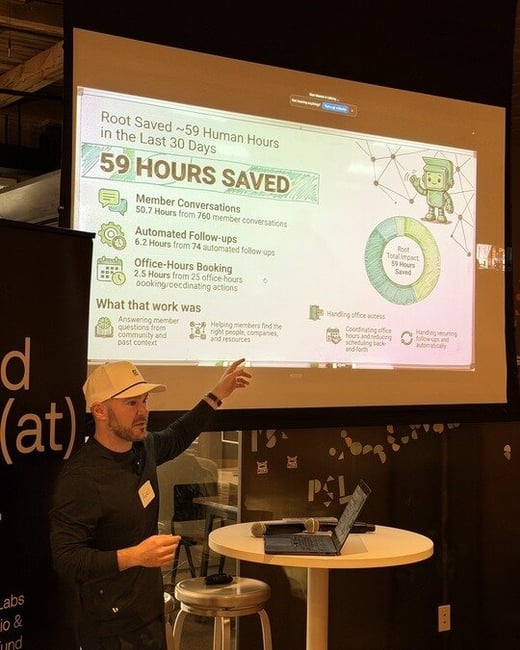 A man in a white baseball cap points to a presentation screen showing data about human hours saved in the last 30 days.