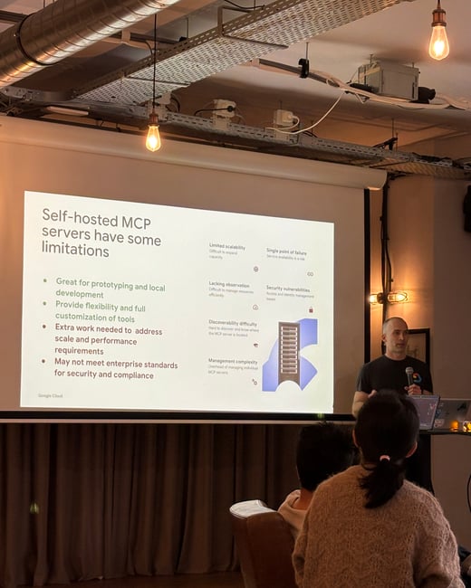 A man stands on a stage giving a technical presentation about self-hosted MCP servers to an audience.