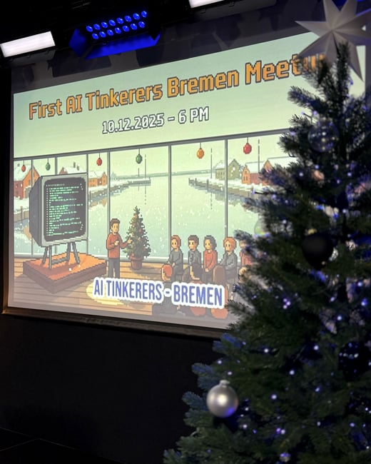 A photograph of a projection screen displaying a pixel-art style event banner for the 'First AI Tinkerers Bremen Meetup' next to a decorated Christmas tree.