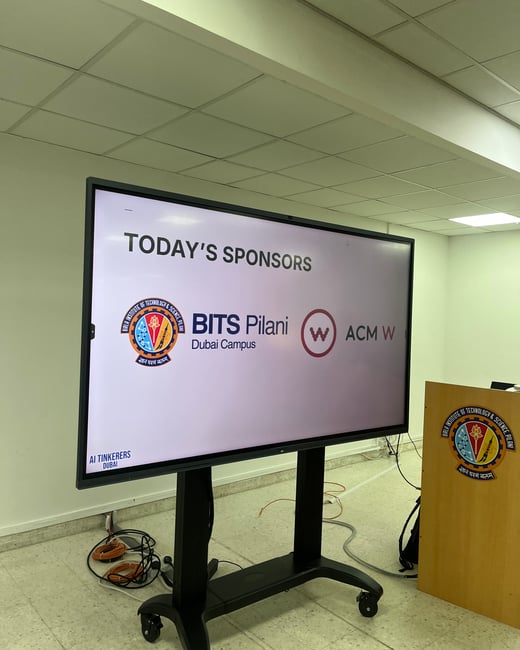A photograph of a digital display screen on a mobile stand inside a classroom or seminar room, showing a slide titled 'TODAY'S SPONSORS'.