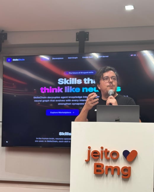 A man stands behind a podium giving a presentation, with a large screen behind him displaying information about 'SkillsChain'.