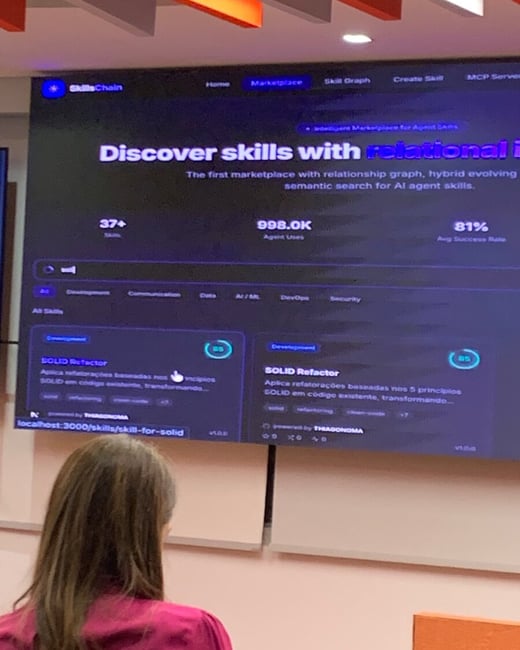 A person with long brown hair, seen from the back, is looking at a large screen displaying a technical dashboard for a platform called 'SkillsChain'.