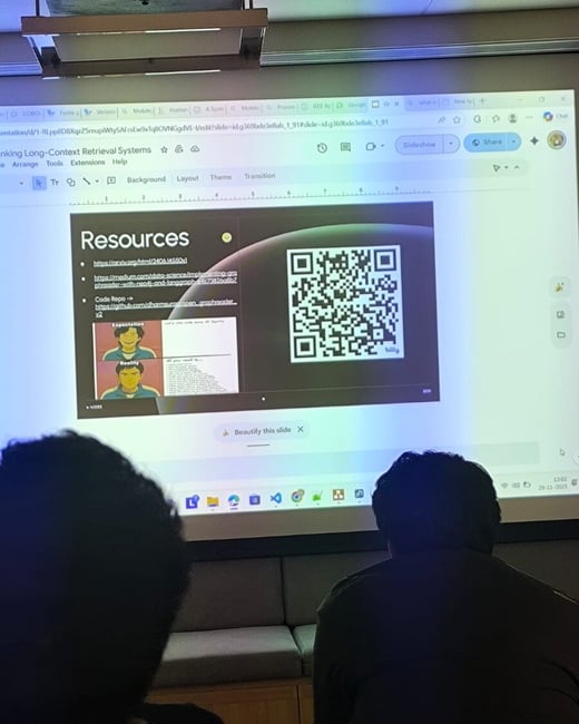 A photograph taken from the audience showing a digital presentation slide projected onto a screen in a dark room, featuring resources, links, and a large QR code related to 'Long-Context Retrieval Systems.' Two attendees are visible in the foreground, seated with their backs to the camera.