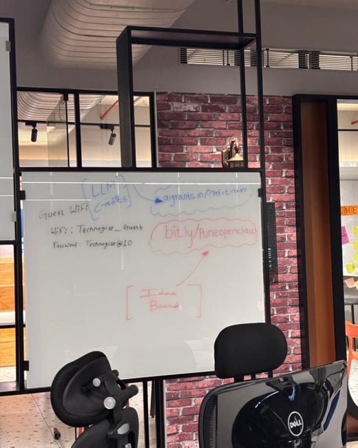 A photograph of a whiteboard in an office setting with handwritten Wi-Fi details and website links.