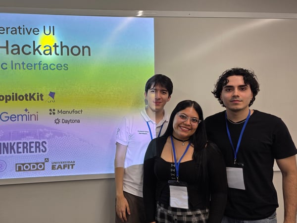 Three individuals posing in front of a projection screen for the 'Generative UI Global Hackathon: Agentic Interfaces' event.