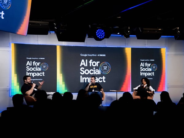 A panel discussion at a Google DeepMind and AI Tinkerers event titled 'AI for Social Impact' in São Paulo, featuring three speakers on a stage.