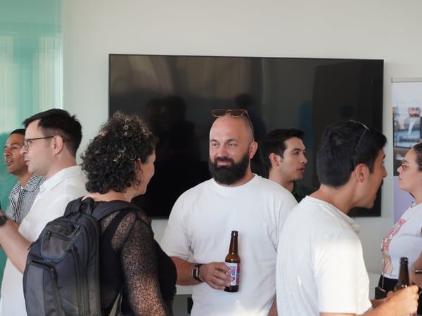 A group of people chatting and socializing at an indoor networking or office event.