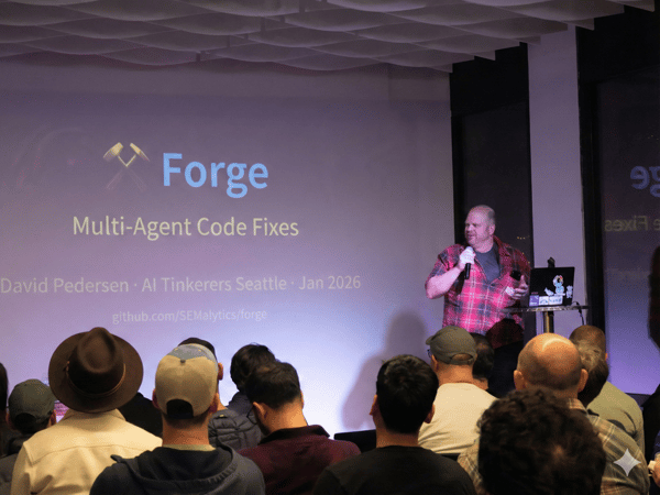 A photograph capturing an indoor tech presentation where a speaker, wearing a red plaid shirt, addresses an audience while standing next to a laptop stand. Behind him, a projection screen displays a title slide for "Forge: Multi-Agent Code Fixes."