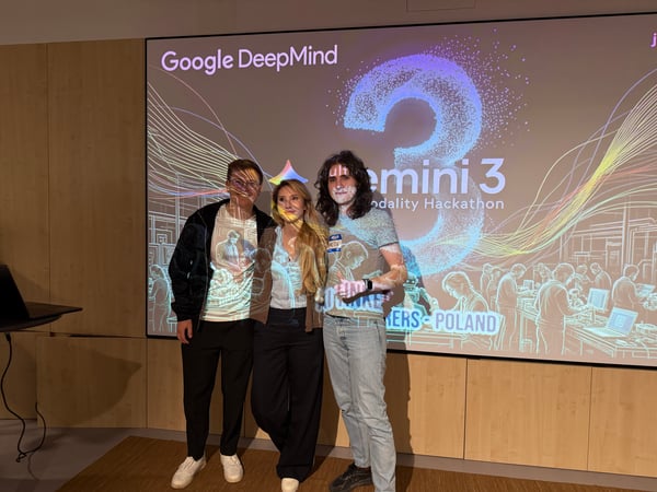 Three people stand in front of a projection screen displaying 'Google DeepMind Gemini 3 Modality Hackathon', with the graphics projected onto them.