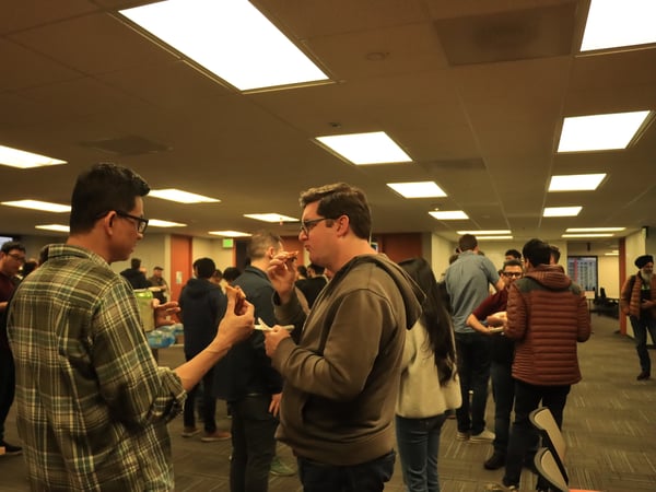 A photograph of people in an indoor setting, with a large grey bar obscuring the bottom half of the image.