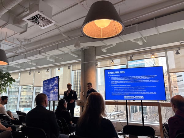 A group of people attend an 'AI News' presentation in a modern office space with large windows overlooking a city.