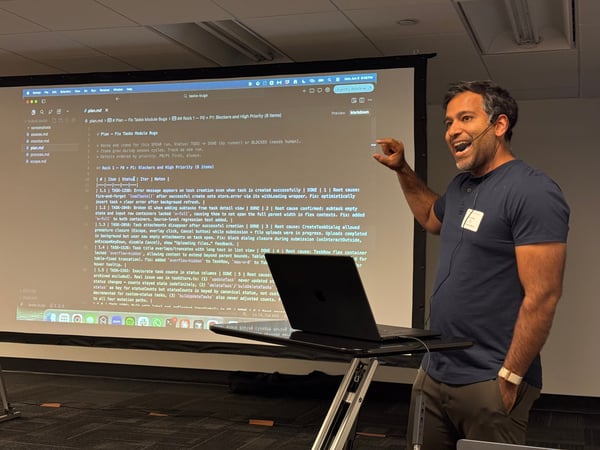 A man is presenting in front of a projection screen displaying markdown notes about fixing task module bugs in a software project.