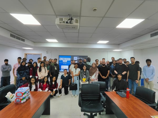 A group photograph of attendees posing together inside a classroom during the AI Tinkerers Dubai event in May 2024.