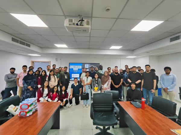 A group photo of attendees posing together inside a classroom or seminar room during an AI Tinkerers Dubai event.
