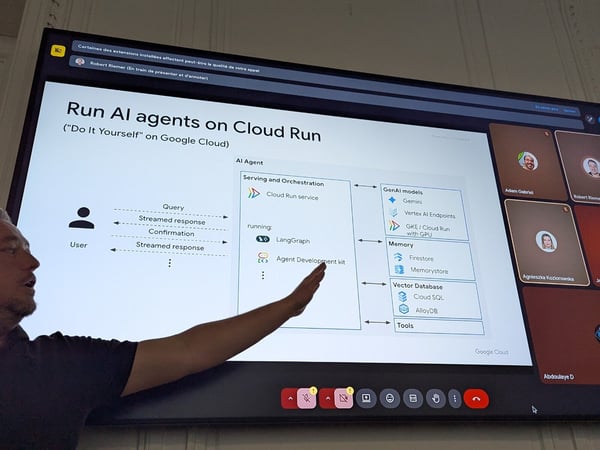 A photo capturing a man giving a technical presentation, pointing at a large screen that displays a slide about running AI agents on Cloud Run, overlaid with a video conferencing interface.
