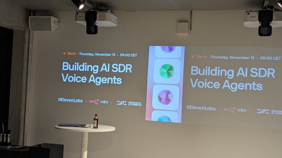 A photograph capturing an indoor event setup, showing a presentation slide projected onto a wall with the title, "Building AI SDR Voice Agents," along with event details and sponsor logos.