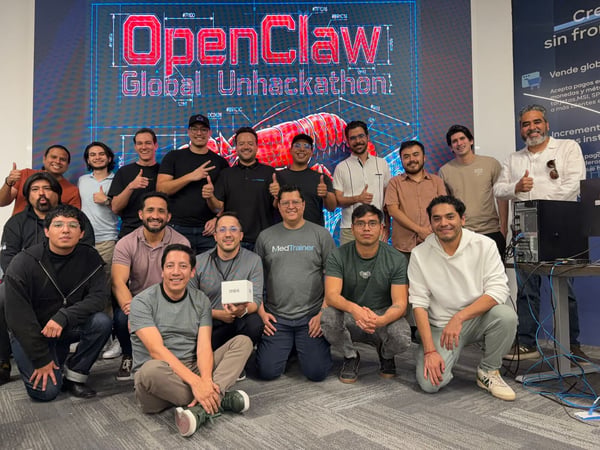 A group of eighteen men posing for a group photograph in front of a large digital screen displaying 'OpenClaw Global Unhackathon'.