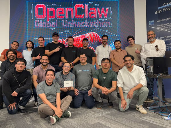 A group of eighteen men posing for a photo in front of a large digital screen displaying 'OpenClaw Global Unhackathon' and a red lobster graphic.