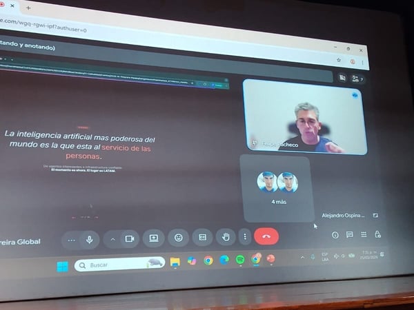 A photograph showing a large projection screen displaying a Google Meet video call and a presentation about artificial intelligence, with a university podium in the foreground.